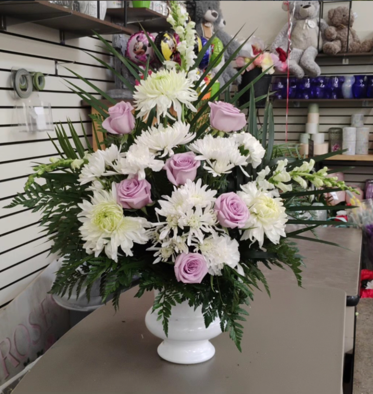 Lavender roses and white chrysanthemum arrangement in white vase