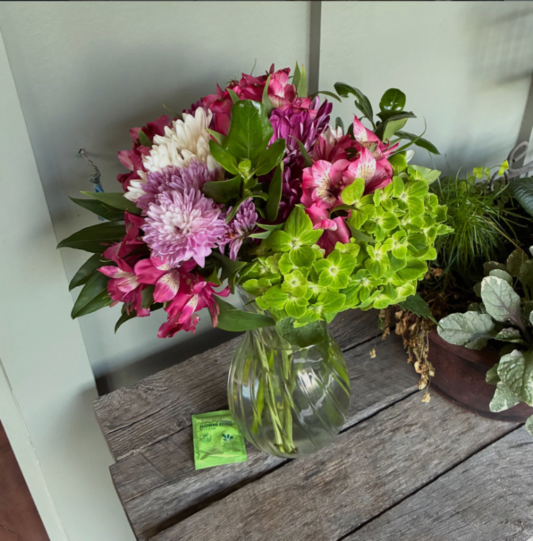 Pink alstroemeria and green hydrangea bouquet in glass vase