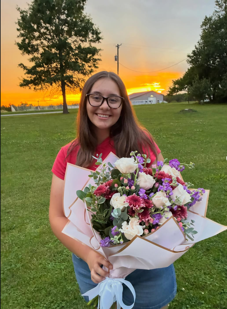 Hannah King holding a beautiful bouquet at sunset